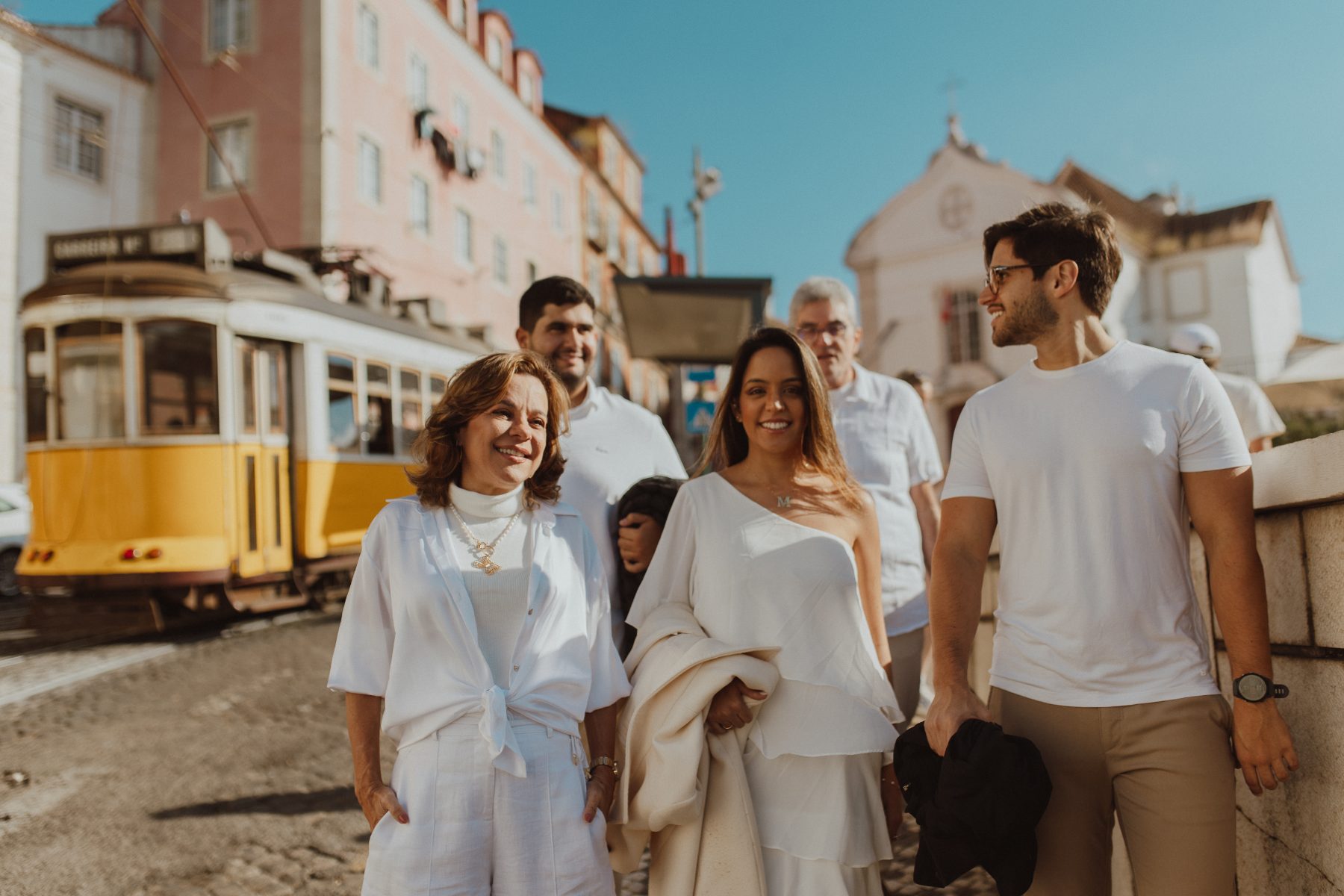 Família caminhando ao lado do elétrico 28 em Alfama
